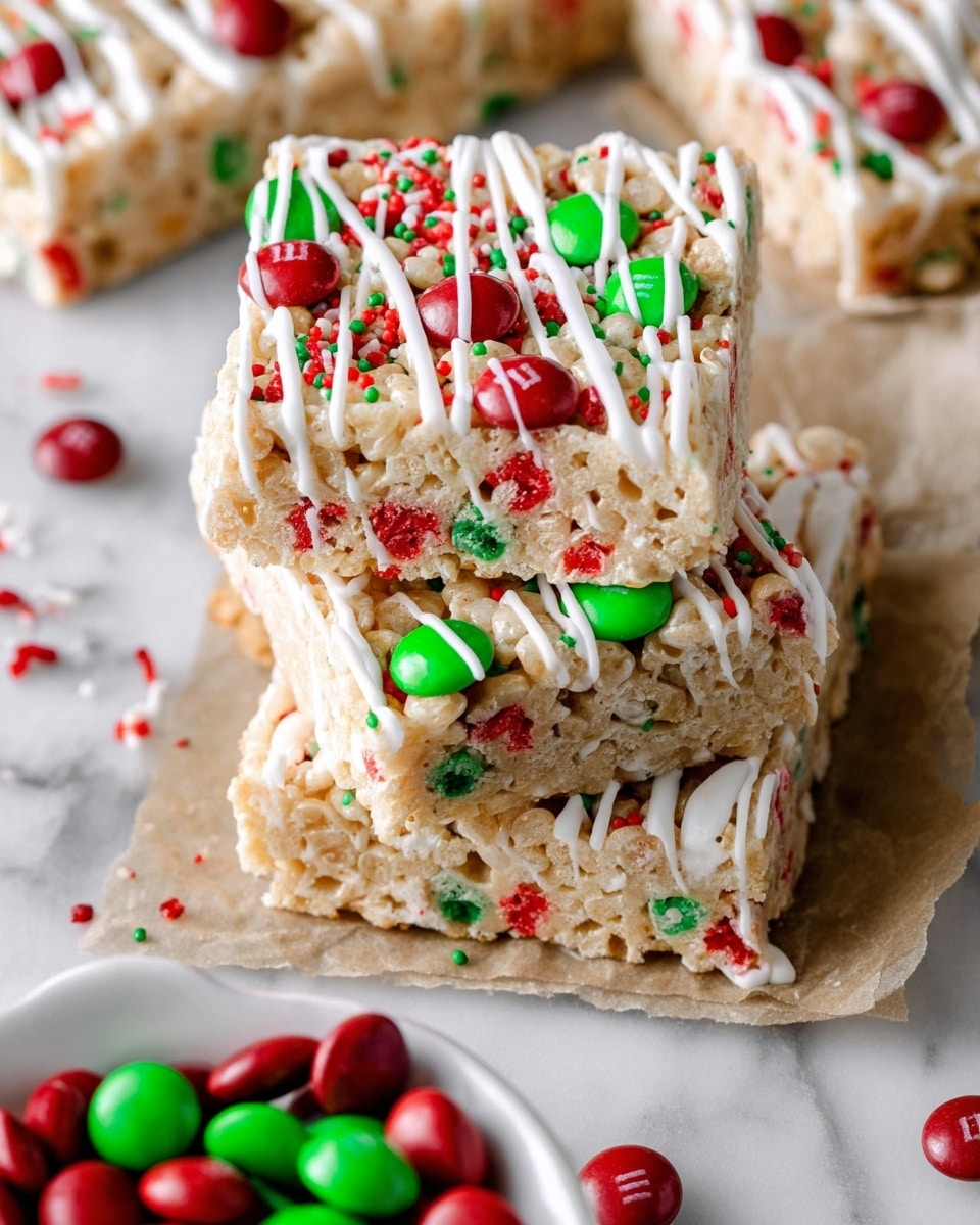 A close-up of three thick, square rice crispy treats stacked on a white marbled surface with brown parchment paper underneath. Each treat has a light golden base with visible rice cereal pieces mixed with red and green sprinkles and whole red and green M&M candies scattered on top and within. White icing is drizzled in uneven lines over the treats, adding a smooth texture contrast. Some extra red and green M&M candies and sprinkles scattered around on the parchment and marbled surface. A white dish filled with red and green M&Ms appears blurred at the bottom of the image. Photo taken with an iphone --ar 4:5 --v 7