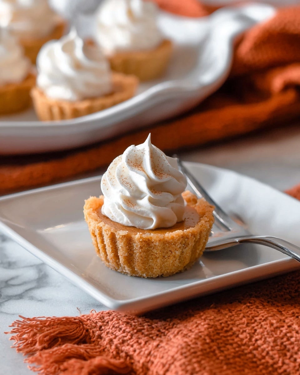 The image shows a small dessert with three layers on a white plate set on a white marbled surface. The bottom layer is crumbly and golden, resembling a nutty or cookie crust. The middle layer is thicker and has a smooth, dense texture with a warm, brownish-orange color, suggesting a pumpkin or spiced filling. On top, there is a swirl of white whipped cream with a soft, fluffy texture. The dessert has a bite taken out of it, showing the layers clearly. The background is softly blurred with a hint of warm colors. photo taken with an iphone --ar 4:5 --v 7