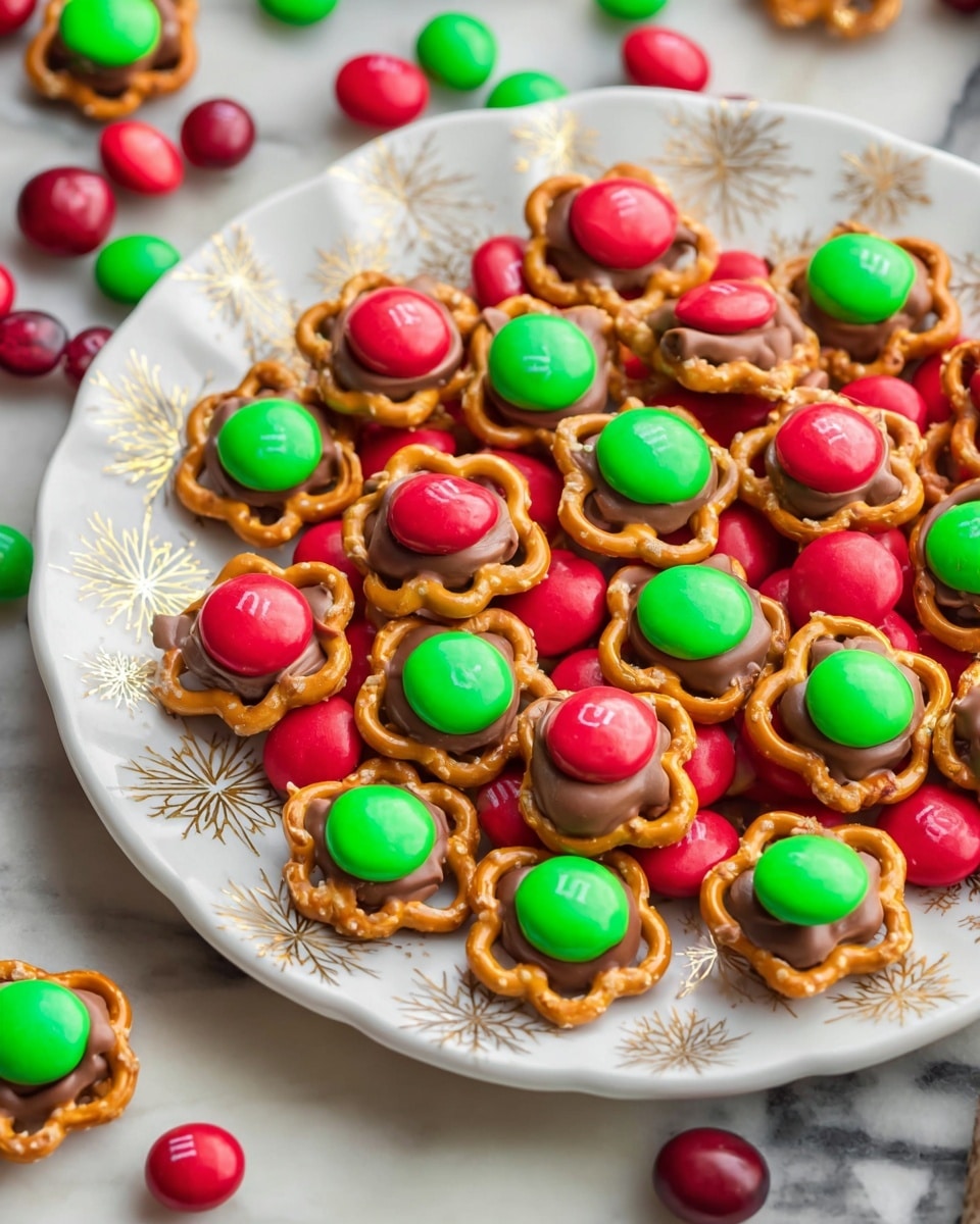 A white plate with silver and gold snowflake patterns is filled with colorful treats arranged in two layers. The bottom layer is scattered with red and green round candy-coated chocolates. On top, there are small clusters each made of a golden brown pretzel in a circular shape, topped by a milk chocolate drop and finished with a single candy-coated chocolate in red or green in the center. The plate rests on a white marbled texture surface, with some candies spilled around it. Photo taken with an iphone --ar 4:5 --v 7