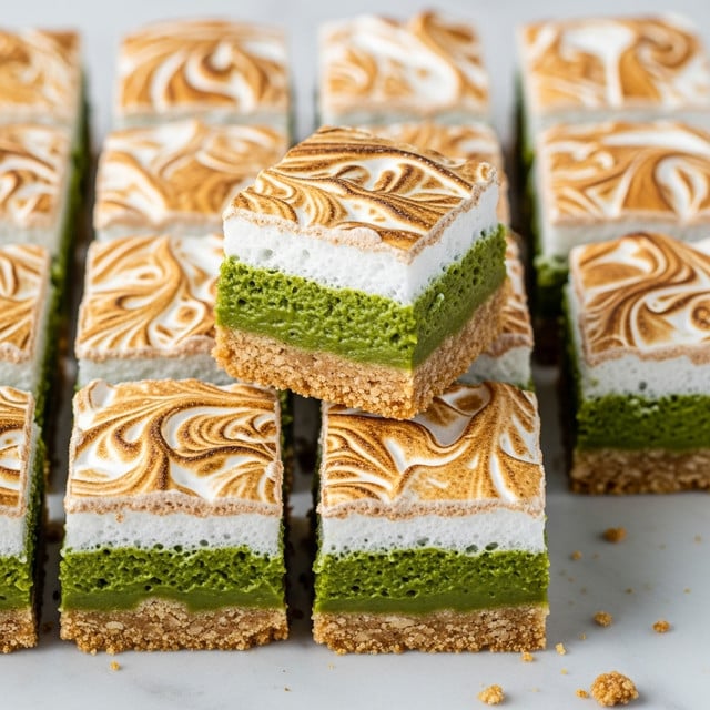 This image shows a batch of square brownies cut into 12 pieces on a white marbled surface. Each piece has two layers: a bottom layer that is golden brown and crumbly, and a top layer that is light cream with swirled brown patterns, giving a marbled texture. One brownie is slightly lifted, showing the dense, greenish middle part between the layers. Crumbs are scattered around the brownies, adding a casual look. photo taken with an iphone --ar 4:5 --v 7