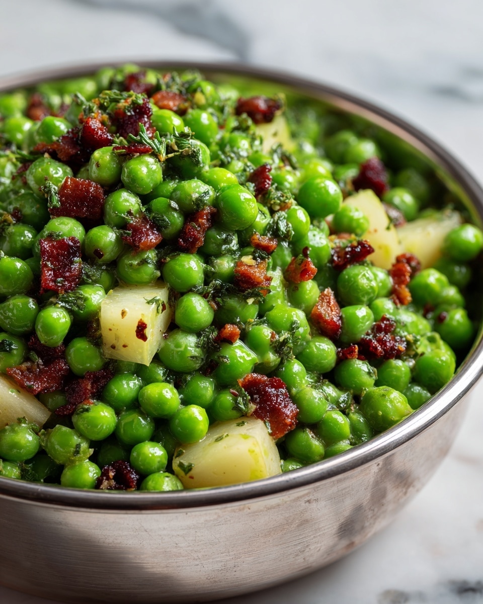 A close-up of a metal bowl filled with a fresh pea salad showing bright green peas as the main layer, scattered with small pieces of crispy bacon that add a dark red-brown color and rough texture. Mixed in are small wedges of light yellow pear, shining with a smooth surface, and sprinkled finely chopped herbs in dark green that add freshness and depth to the top. The metal bowl reflects light softly and sits on a white marbled texture. photo taken with an iphone --ar 4:5 --v 7