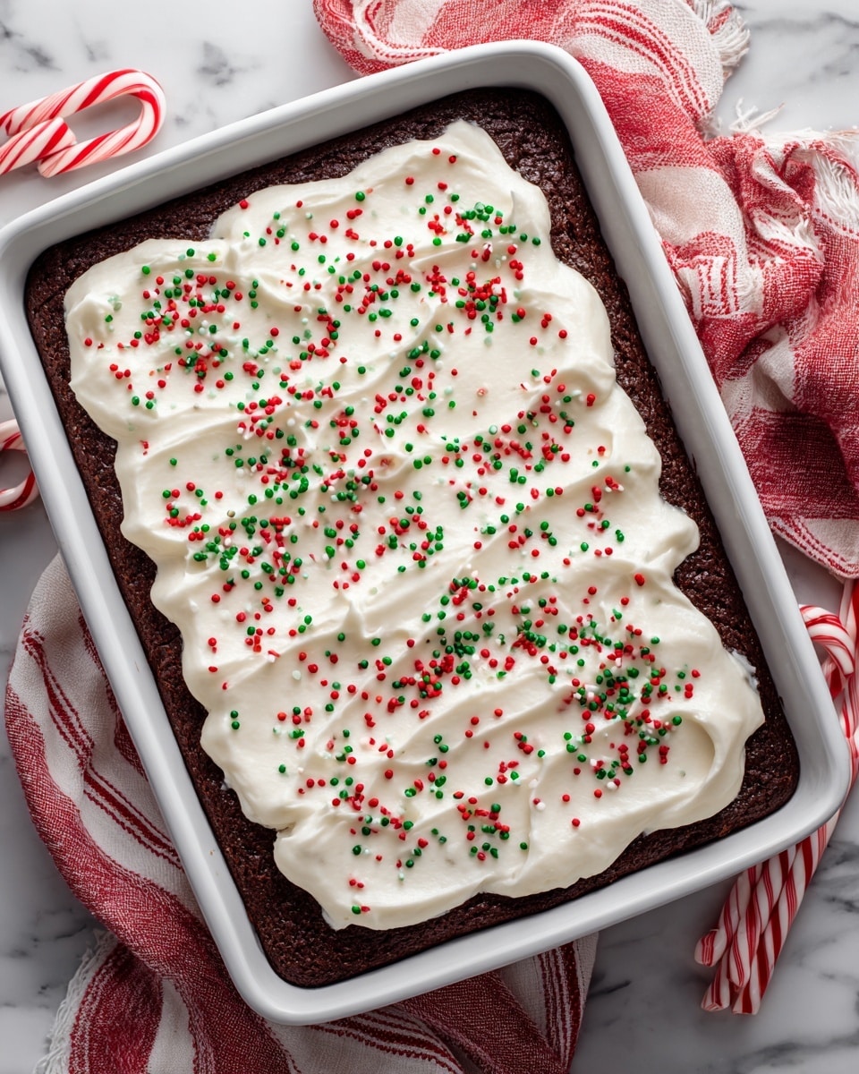 A rectangular cake in a white pan, topped with a smooth, thick layer of white frosting. The frosting has gentle swirls made with a spatula, creating soft waves on the surface. Red, green, and white small round sprinkles are spread evenly across the top, adding festive color. The pan rests on a white marbled surface, with two red and white candy canes placed beside it. Photo taken with an iphone --ar 4:5 --v 7