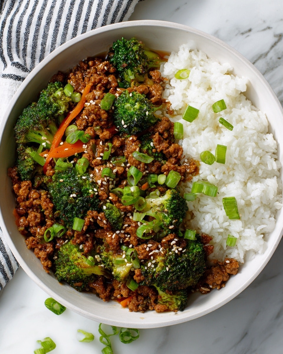 A white bowl filled with two main layers: fluffy white rice on one side and a colorful stir-fry mixture on the other. The stir-fry contains small pieces of cooked ground meat with a glossy brown sauce, bright green broccoli florets, thin orange carrot strips, and chopped green onions sprinkled on top. White sesame seeds are scattered over the stir-fry, adding texture. The bowl is placed on a white marbled surface with a blurred striped cloth in the background. Photo taken with an iphone --ar 4:5 --v 7