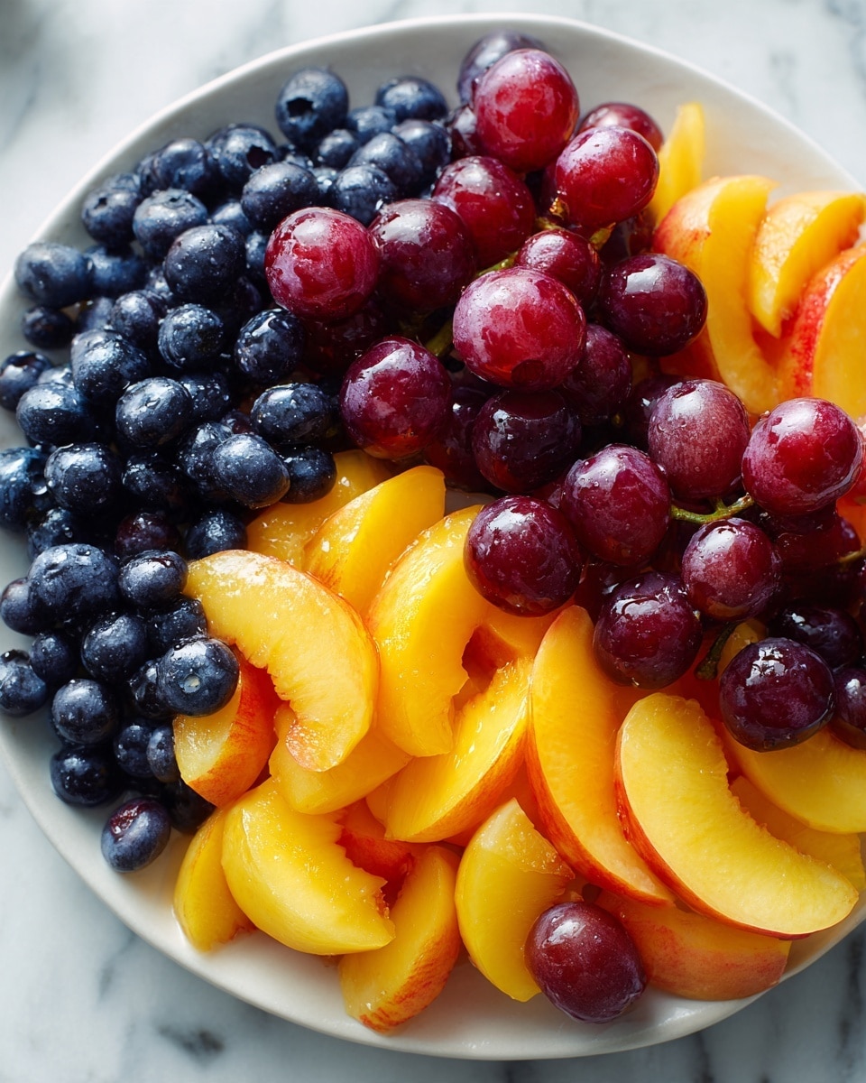 A white bowl filled with multiple layers of fresh fruit, starting with a base layer of dark blueberries, followed by slices of bright orange peaches and red plums arranged neatly on top. There are also green grapes scattered evenly across the fruit layers, adding a pop of color and texture. The fruit looks fresh and juicy with a slight shine, and the bowl sits on a white marbled surface. photo taken with an iphone --ar 4:5 --v 7
