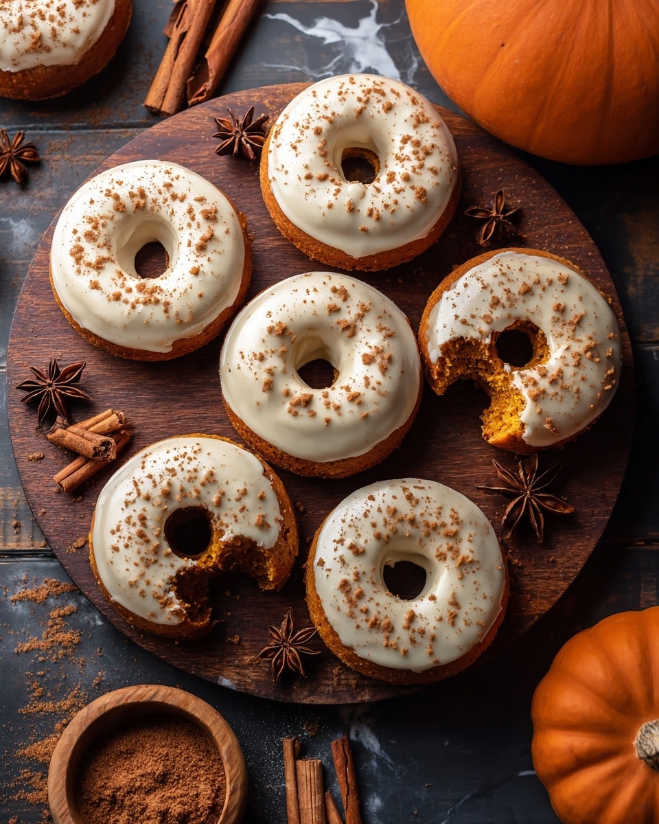 The image shows seven round donuts with a light brown base and a smooth, shiny white icing that covers the top layer completely. One donut has a small bite taken out, revealing a soft, textured inside with a golden brown color. Some donuts have a light sprinkle of brown spice powder on the icing. They are placed close together on a white marbled surface with dark wooden bowls of brown spice powder and star anise, and a few star anise and cinnamon sticks scattered around. There is a small orange pumpkin visible in the top right corner. Photo taken with an iphone --ar 4:5 --v 7